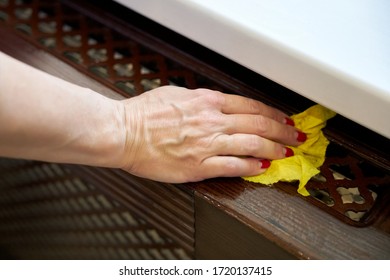 Woman Wipes A Window Sill With A Damp Yellow Rag.