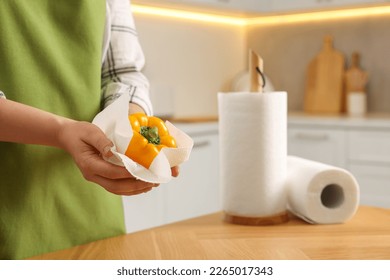 Woman wiping bell pepper with paper towel in kitchen, closeup. Space for text - Powered by Shutterstock