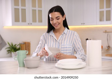 Woman Wiping Bowl With Paper Towel In Kitchen