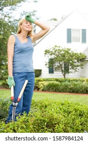 Woman With Wiping Brow Holding Shears