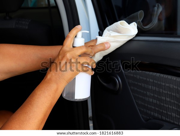 Woman wiping car\
interior with alcohol and cloth cleaning car. Interior Cleaning.\
Covid-19 prevention.  