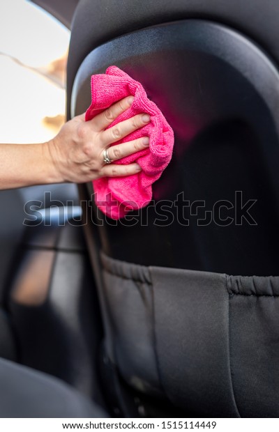 Woman\
wiping dust from car interior parts with a\
cloth