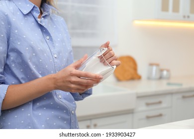 Woman Wiping Glass With Paper Towel In Kitchen, Closeup