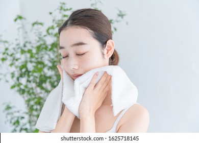 Woman Wiping Her Face With A Towel