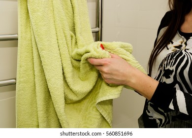 Woman Is Wiping Her Hands Using Green Towel In Bathroom