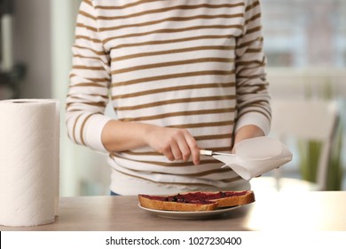 Woman Wiping Knife With Paper Towel In Kitchen