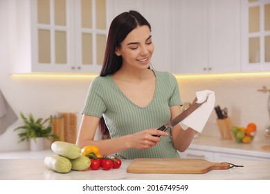 Woman Wiping Knife With Paper Towel In Kitchen