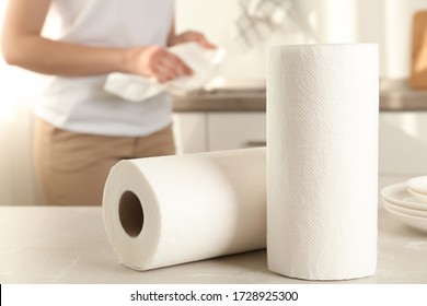 Woman Wiping Plate With Towel In Kitchen, Focus On Paper Rolls