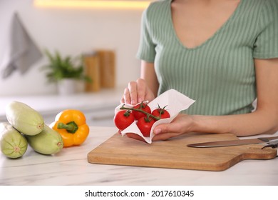 Woman Wiping Tomatoes With Paper Towel In Kitchen, Closeup