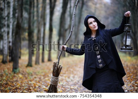 A woman in a witch suit in a dense forest on a ritual