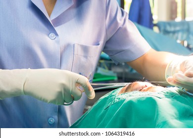 The woman wore gloves suturing faces to the patient sleeps on the bed at the emergency room of the hospital. - Shutterstock ID 1064319416