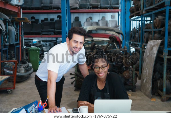 Woman work with man,\
smile and happy together. Diversity of two people, black African\
worker woman and caucasian business manager smile and happy\
together in\
factory-warehouse