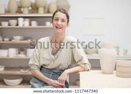 Similar – Woman in work wear in her workshop by table with handmade items