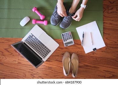 woman work and workout at home for healthy concept and work life balance.  With laptop and workout equipments. top view.
