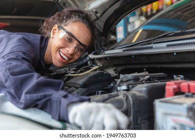 Woman worker at automobile service center, Female in auto mechanic work in garage car technician service check and repair customer car, inspecting car under hood battery engine oil change - Powered by Shutterstock