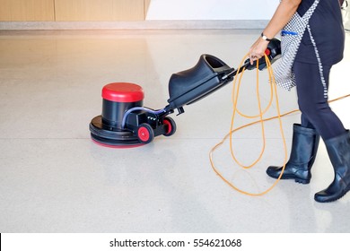 Woman worker cleaning the floor with polishing machine