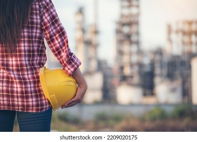 Woman Worker Hands Holding Hardhat Yellow Work Helmet Construction Engineer. Refinery Woman Worker Oil Petro Industry Hand Hold Yellow Worker Helmet Hard Hat. Refinery Industry Engineer Manufacture