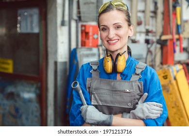 Woman worker in her metal workshop posing with tools - Powered by Shutterstock