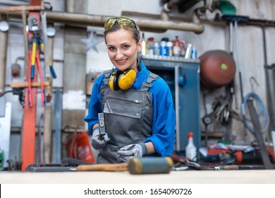 Woman Worker Marking Workpiece In Her Workshop Looking Into Camera