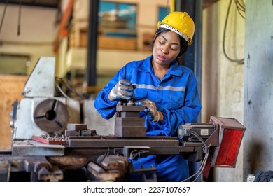 Woman worker in uniform operating machine at factory concentrate on fabrication job on lathe - Shutterstock ID 2237107667