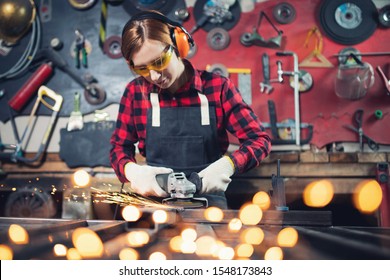 Woman working with angle grinder cuts and polishes metal after welding with spark. - Powered by Shutterstock