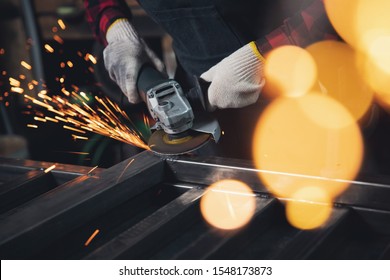 Woman working with angle grinder cuts and polishes metal after welding with spark. - Powered by Shutterstock