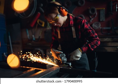 Woman working with angle grinder cuts and polishes metal after welding with spark. - Powered by Shutterstock