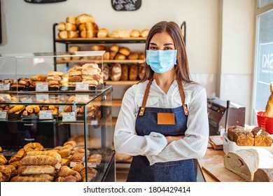 Woman working at a bakery wearing a facemask to avoid the coronavirus. COVID-19 lifestyle concepts. Day in the life of owners of bakery shop with the protocol against the Covid-19 in place.  - Shutterstock ID 1804429414
