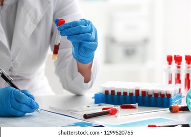 Woman Working With Blood Sample In Laboratory