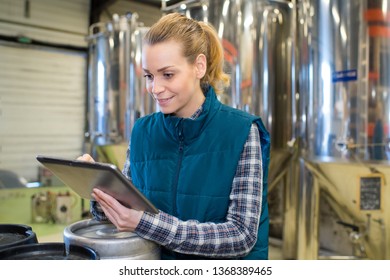 woman working in brewery using digital tablet - Powered by Shutterstock