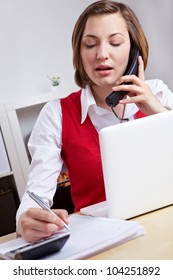 Woman Working In Call Center And Taking Notes On The Phone