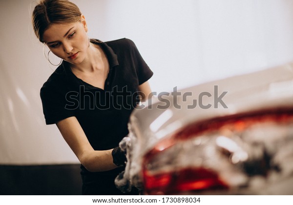 Woman working at\
a car wash detailing\
station