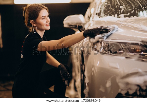 Woman working at
a car wash detailing
station