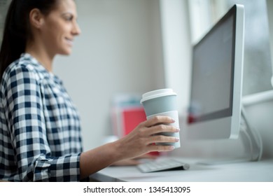 Woman Working At Computer Drinkinking From Reusable Takeaway Cup