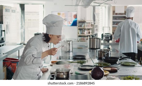 Woman Working As Cook Testing Bad Soup For Gourmet Dish, Making Mistake In Preparing Culinary Recipe. Authentic Chef Doing Taste Test With Sauce, Cooking In Professional Gastronomy Kitchen.