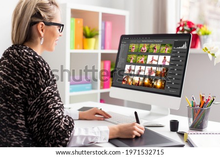 Woman working with digital photo library on desktop computer and editing photos