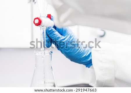 Woman working with a Funnel in a Chemistry Lab