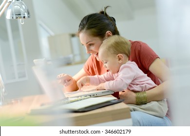 Woman working from home with baby on lap