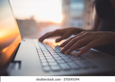 Женщина, работающая в домашнем офисе, рука на клавиатуре крупным планом
