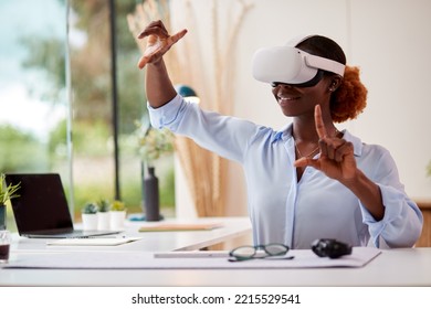 Woman Working From Home Office Sitting At Desk Wearing VR Headset Interacting With AR Technology - Powered by Shutterstock