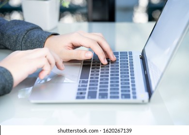 Woman working at home office using laptop searching web, browsing information ,Hand on keyboard close up - Shutterstock ID 1620267139
