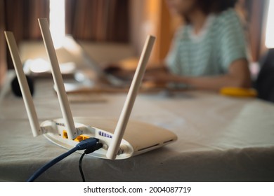 A Woman Is Working At Home Using A Modem Router, Connecting The Internet To Her Laptop.