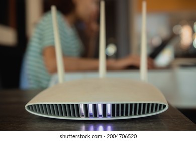 A Woman Is Working At Home Using A Modem Router, Connecting The Internet To Her Laptop.