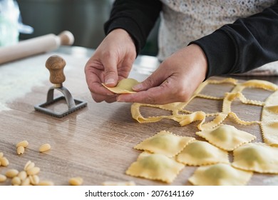 Woman working inside pasta factory while doing fresh made ravioli with vintage stamp - Powered by Shutterstock