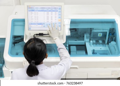 Frauen, die in einem Labor an einer modernen Bluttestmaschine arbeiten. Der Arzt kontrolliert das Blut der Patienten. Blutforschung an einem modernen wissenschaftlichen Arbeitsplatz.