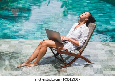Frauen arbeiten mit Laptop am Pool. Freiberufliche Tätigkeit in tropischen Ländern