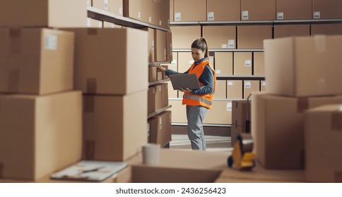 Woman working with a laptop at the warehouse, logistics and shipping concept - Powered by Shutterstock