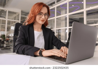 Woman working with laptop at white desk in office - Powered by Shutterstock