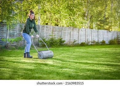 Woman working with lawn roller in the garden - Powered by Shutterstock