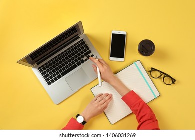 Woman Working With Modern Laptop At Color Table, Top View